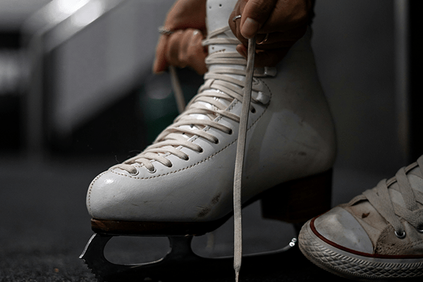 person lacing their ice skates